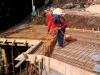Electrician laying cable conduits on the roof of the lower level before the slab is laid