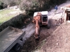 Bagger digging out the second phase of the retaining wall
